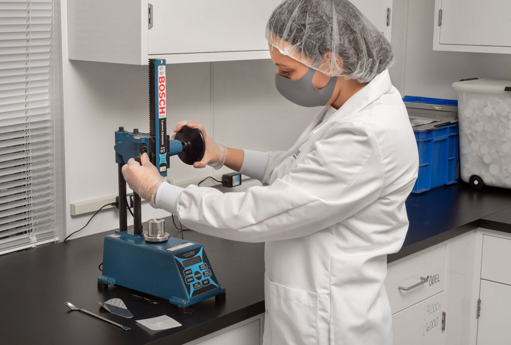 Scientist at Vitaquest testing custom supplement blends with advanced equipment.