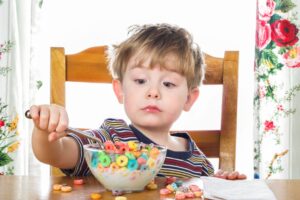 Boy making a face while eating breakfast cereal