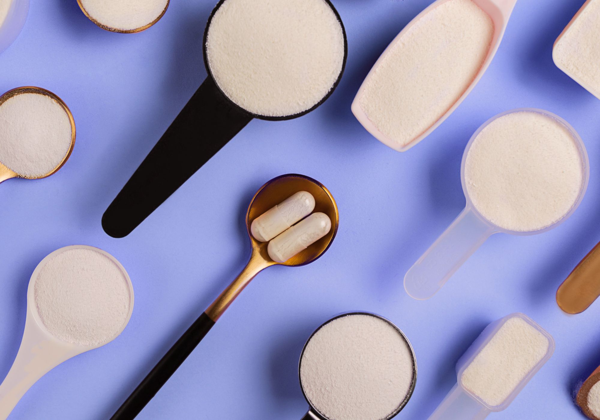 An image of collagen powder and capsules in a variety of scoops and spoons.