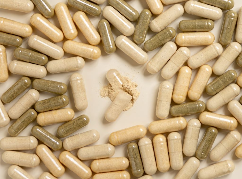 An opened supplement capsule intended to help show the differences between vegan vs. gelatin capsules.