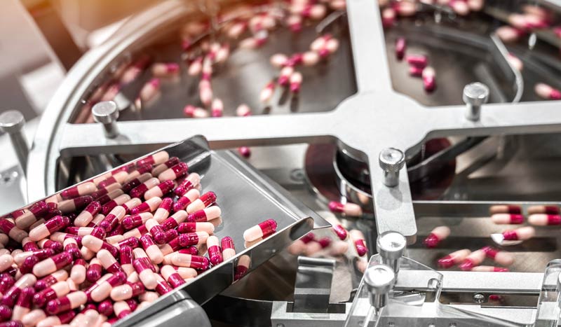 Capsules being produced in machinery. Capsules being produced in machinery.