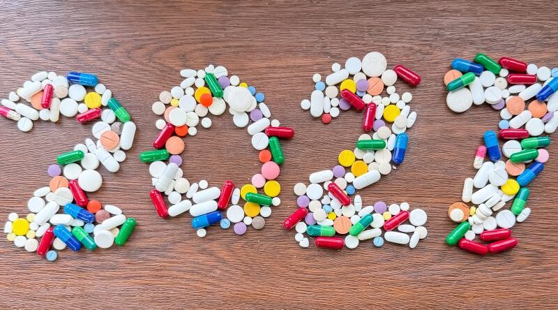 Supplement trends for 2027 illustrated with colorful capsules and tablets arranged to form the year 2027 on a wooden background.