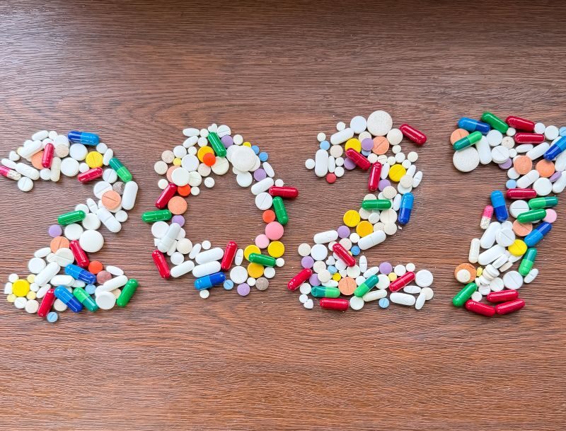 Supplement trends for 2027 illustrated with colorful capsules and tablets arranged to form the year 2027 on a wooden background.