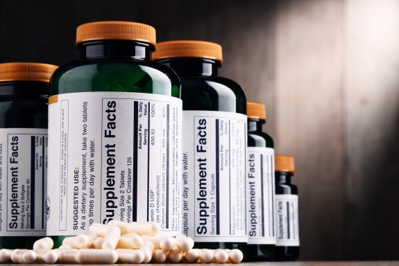 Supplement Facts vs Nutrition Facts differences illustrated with supplement bottles and capsules