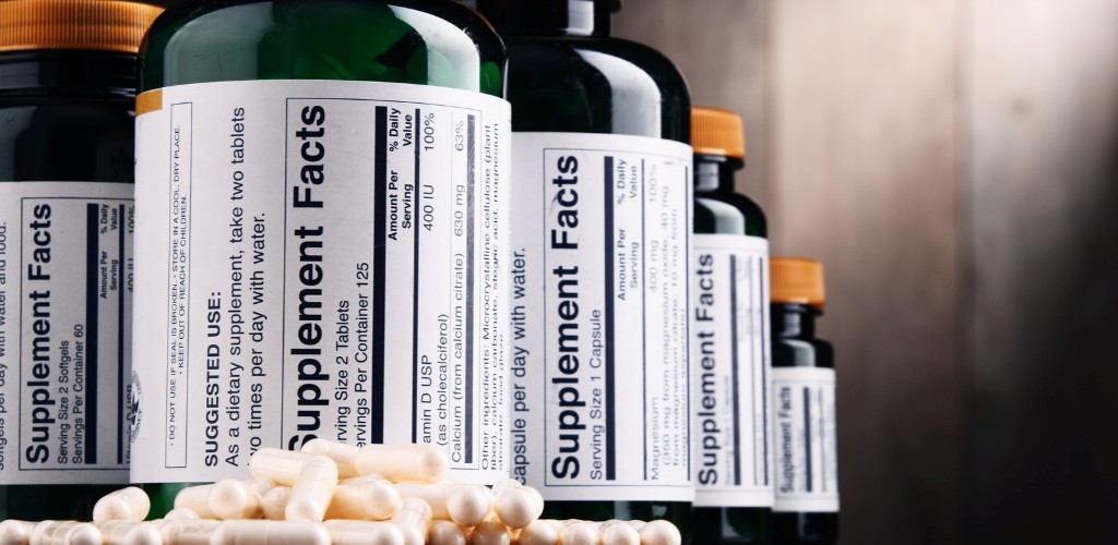 Supplement Facts vs. Nutrition Facts differences illustrated with supplement bottles and capsules