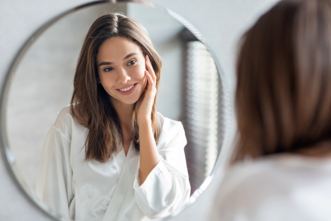 Woman looking at her reflection in a beauty image exploring what are nutricosmetics
