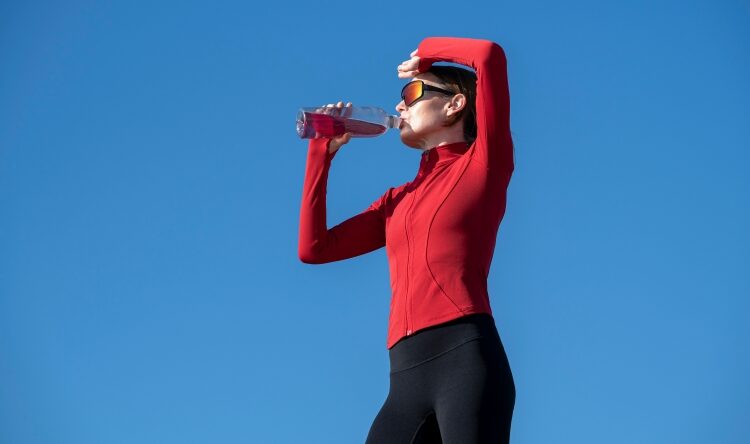 Hydration supplement flavor trends illustrated by a woman taking a hydration break outdoors.