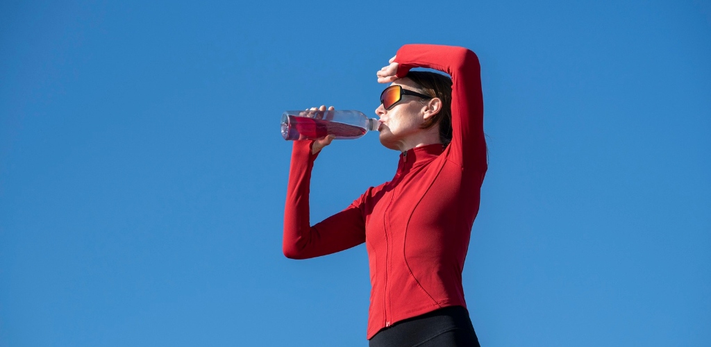 Hydration supplement flavor trends illustrated by a woman taking a hydration break outdoors.